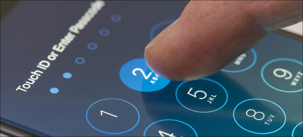 Tocar con el dedo un código de acceso en la pantalla de un iPhone.