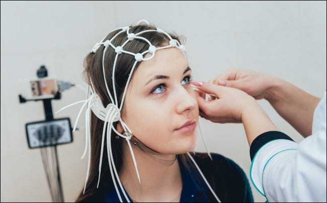 Un médico colocando electrodos en la cabeza de un paciente.