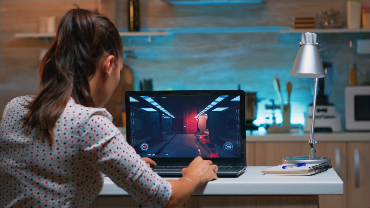 Mujer joven jugando en una computadora portátil