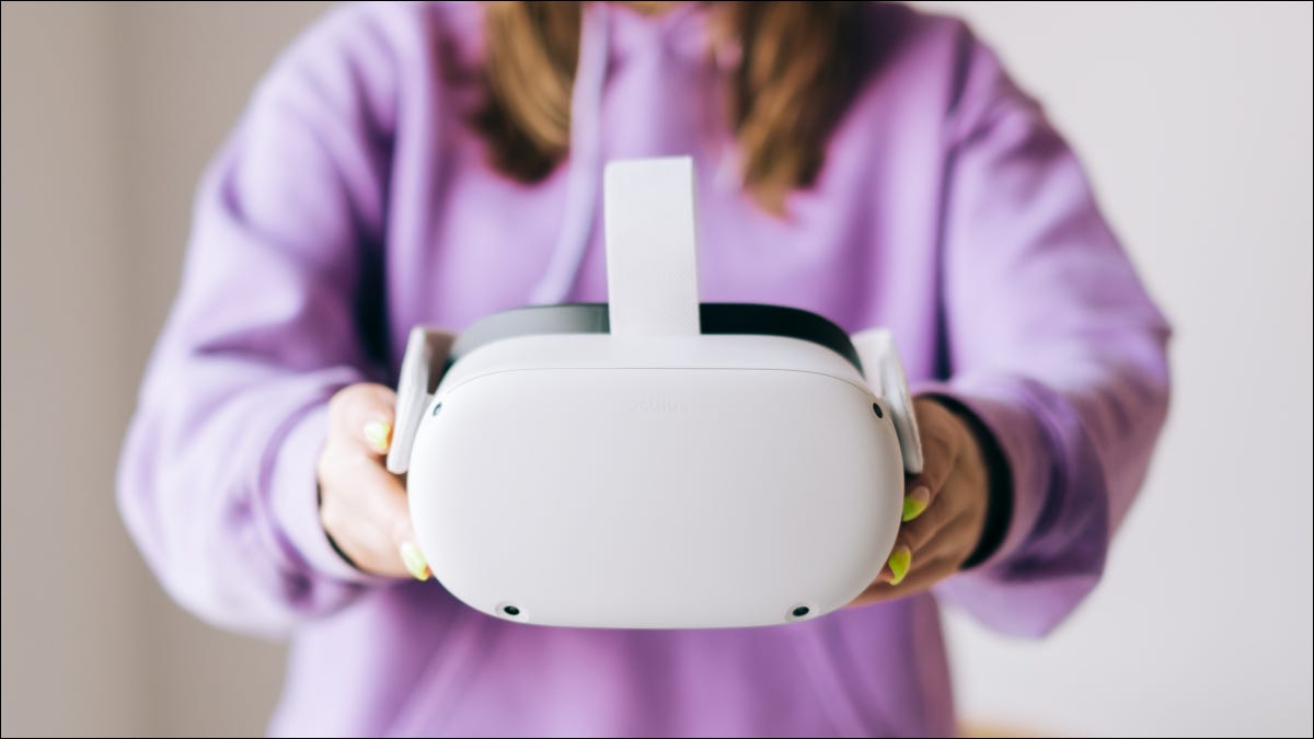 Una mujer sosteniendo un visor de realidad virtual Oculus Quest 2.