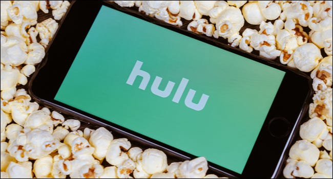 Hulu en el teléfono rodeado de palomitas de maíz