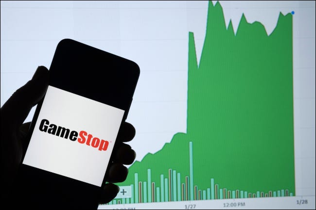 Un teléfono inteligente que muestra el logotipo de GameStop frente a un gráfico de aumento del valor de las acciones.