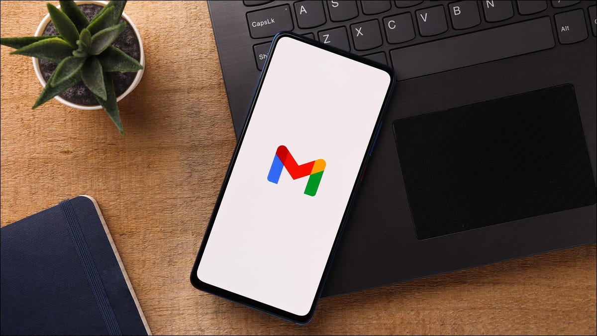 Logotipo de Gmail en un teléfono inteligente junto a una computadora