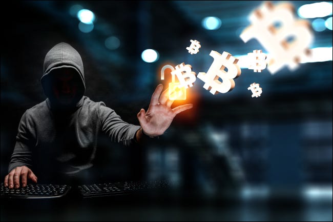 Una figura de hacker encapuchado dibujando símbolos de Bitcoin con la mano.