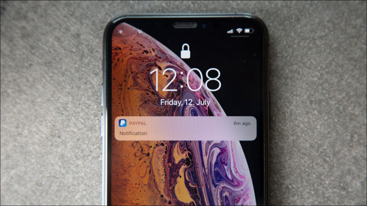 La pantalla de bloqueo de un iPhone con una notificación de PayPal.
