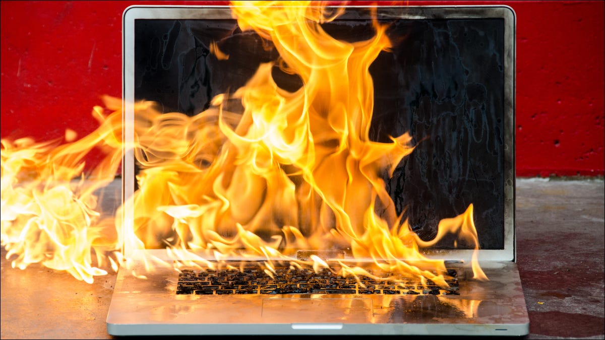 Una computadora portátil en llamas, envuelta en llamas.