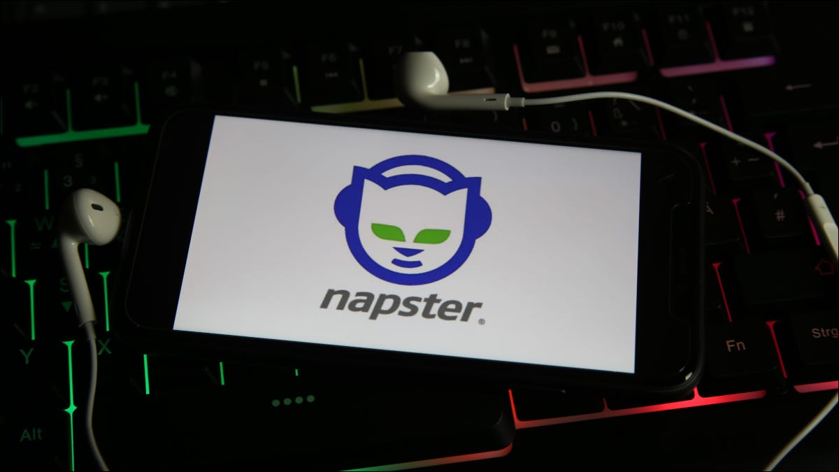 Teléfono inteligente que muestra el logotipo de Napster y está rodeado de auriculares adjuntos.