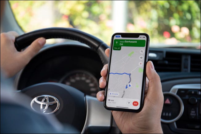 Una persona navegando en un automóvil con Google Maps en un iPhone.