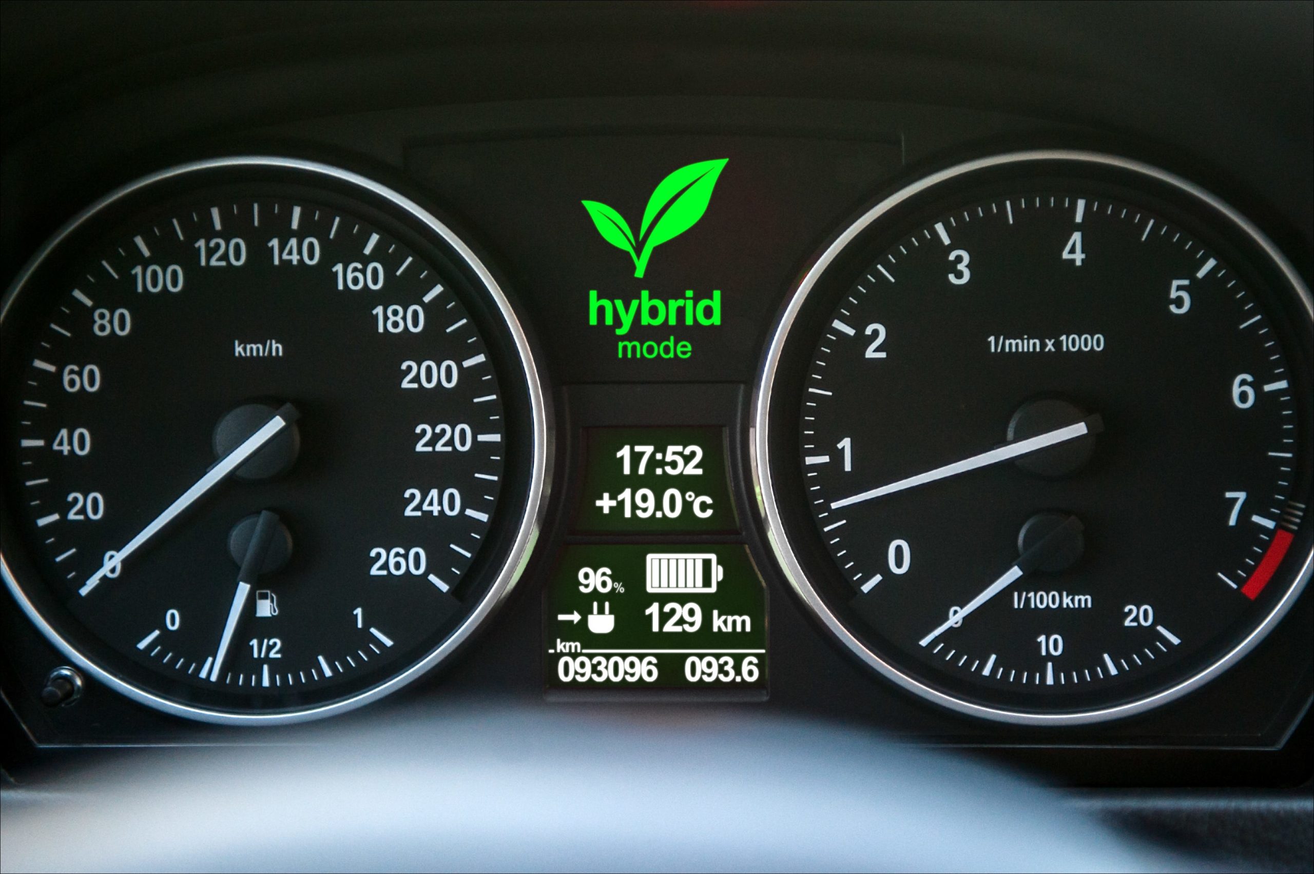 Primer plano de la pantalla del tablero de un automóvil híbrido con la luz "Modo híbrido" activada.