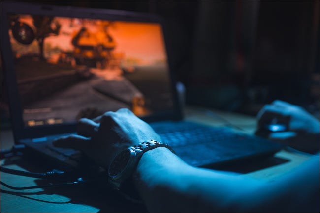 Una persona jugando en una computadora portátil.