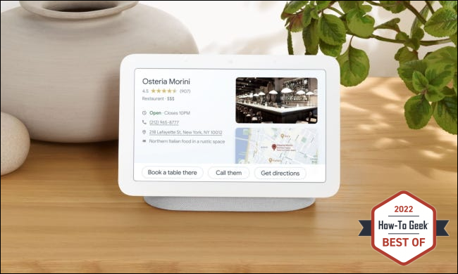 Google Nest hub sobre una mesa con macetas