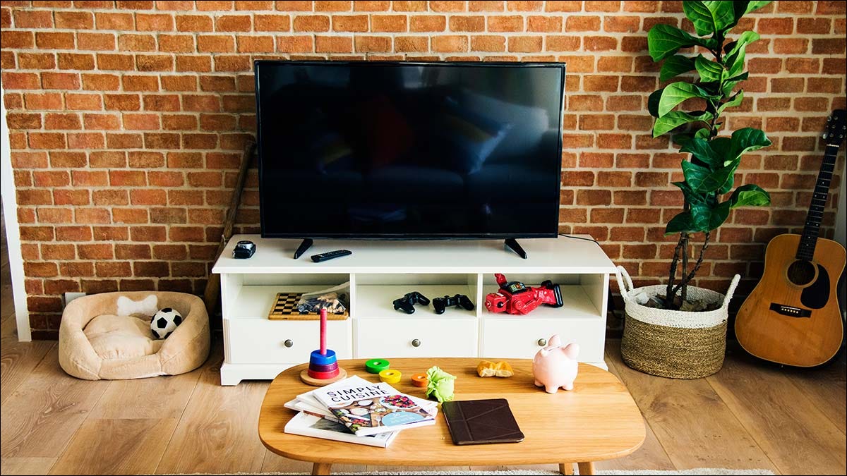 Una sala de estar con un televisor en un soporte de consola blanco.