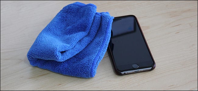 Un paño de microfibra azul junto a un iPhone.