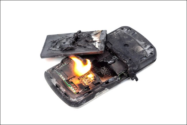 Un teléfono móvil en llamas con una batería explotada.