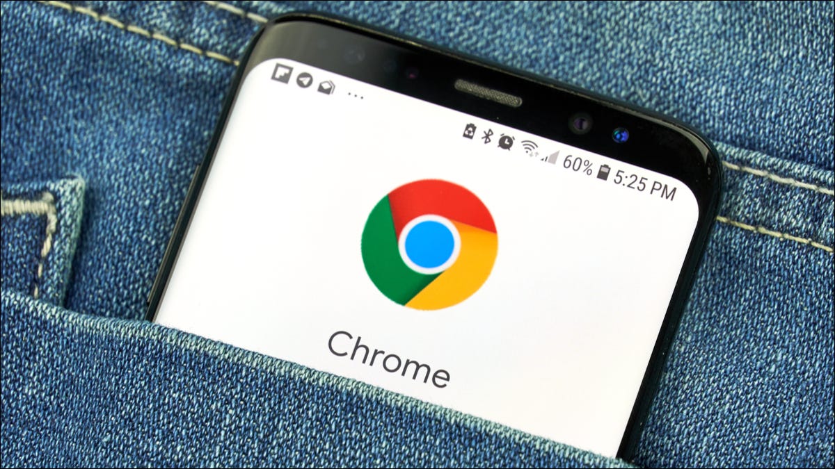 El logotipo de la aplicación Chrome en un teléfono Android escondido en el bolsillo de mezclilla de una persona.