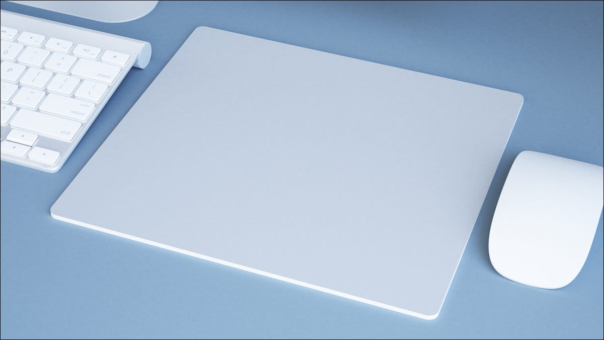 Una moderna alfombrilla de ratón blanca junto a un ratón y un teclado.