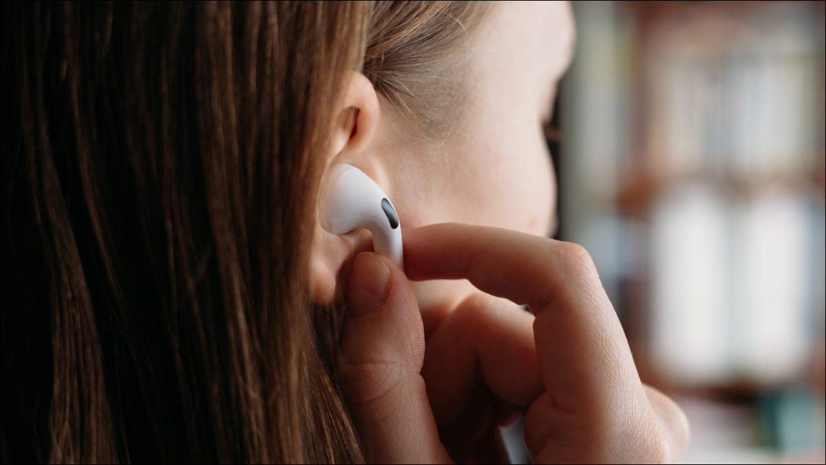Mujer colocando Apple Airpods en el oído