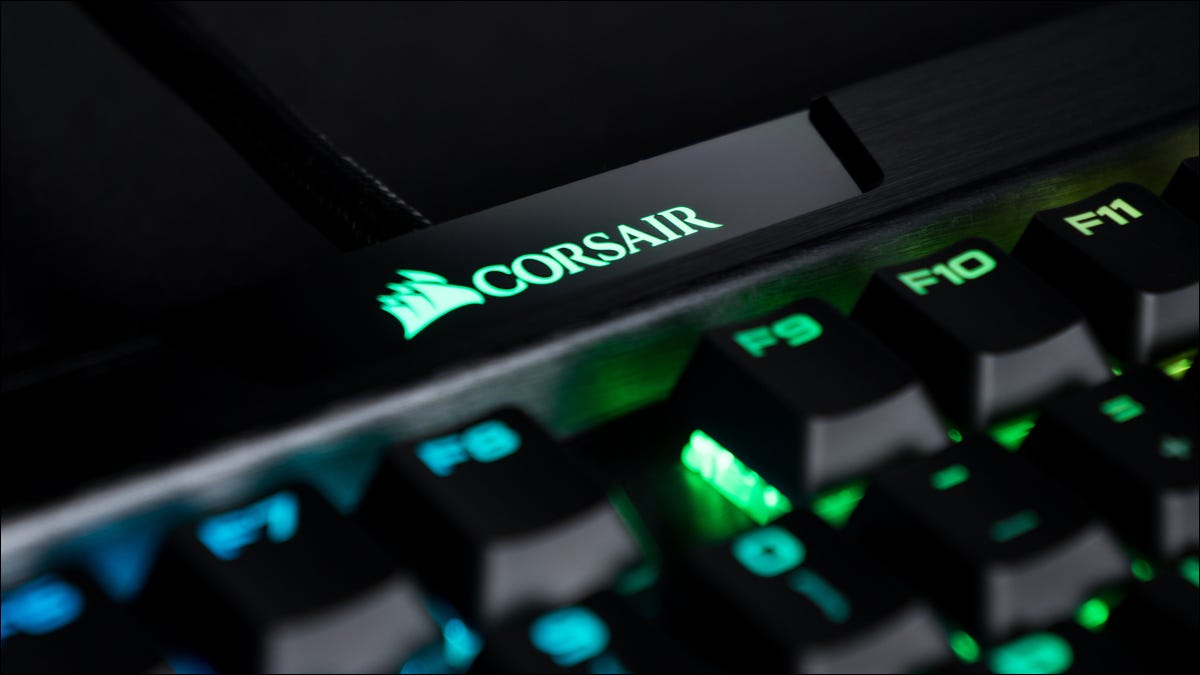 Primer plano de un logotipo de Corsair en un teclado con iluminación RGB.