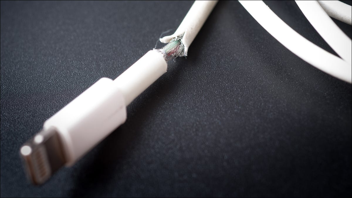 Primer plano de un cable de carga de teléfono inteligente dañado.