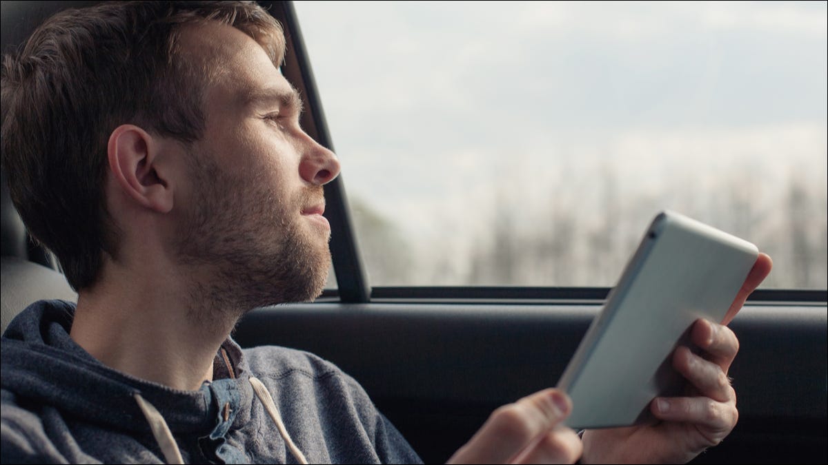 Hombre en un auto usando una tableta.