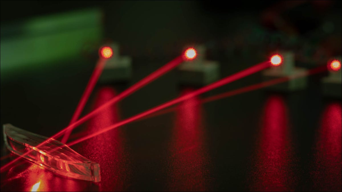 Cuatro láseres rojos instalados en un laboratorio fotónico.