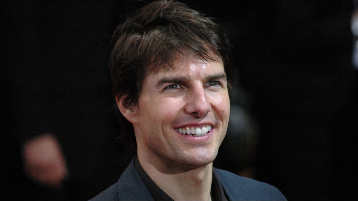 El actor Tom Cruise sonriendo para las cámaras en el estreno de una película.